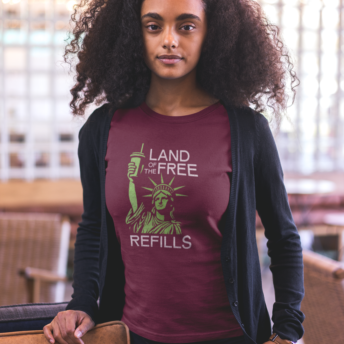 Woman wearing a maroon t-shirt with a design that says Land of the Free Refills.